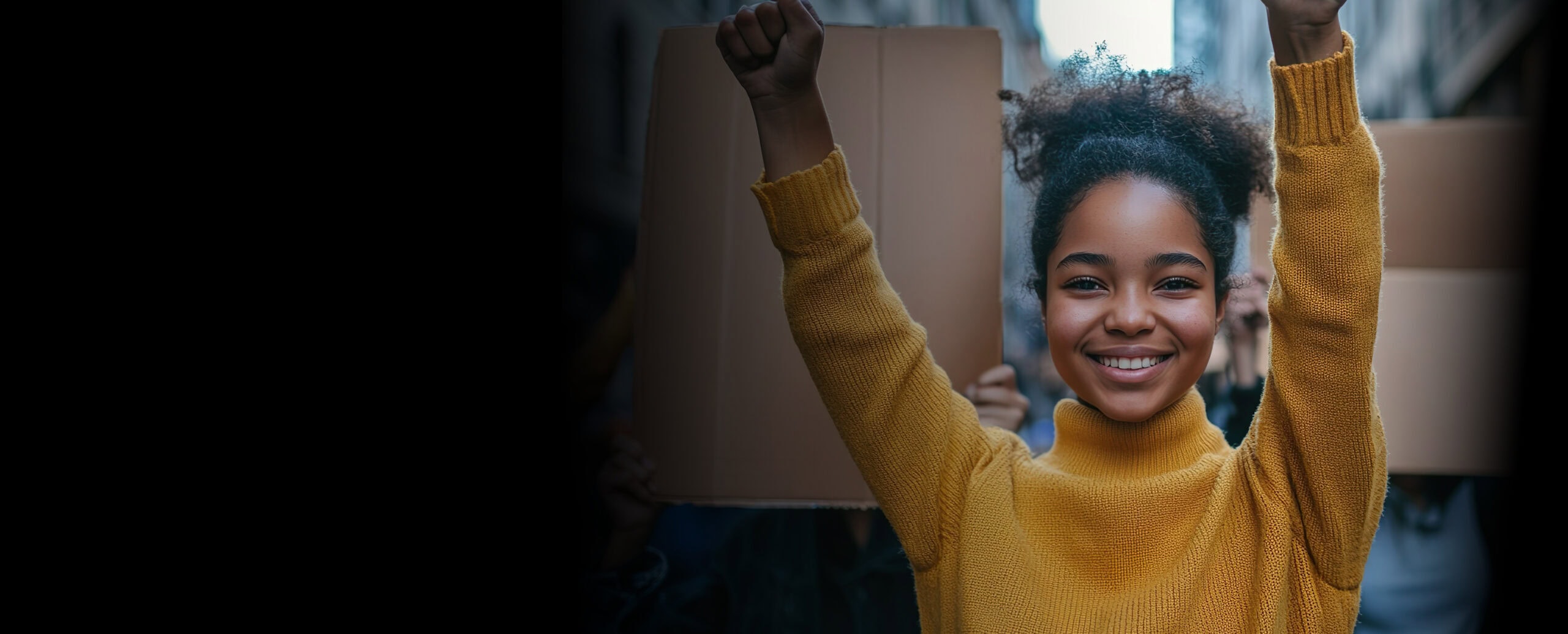 Young woman raising fist in a protest or rally.